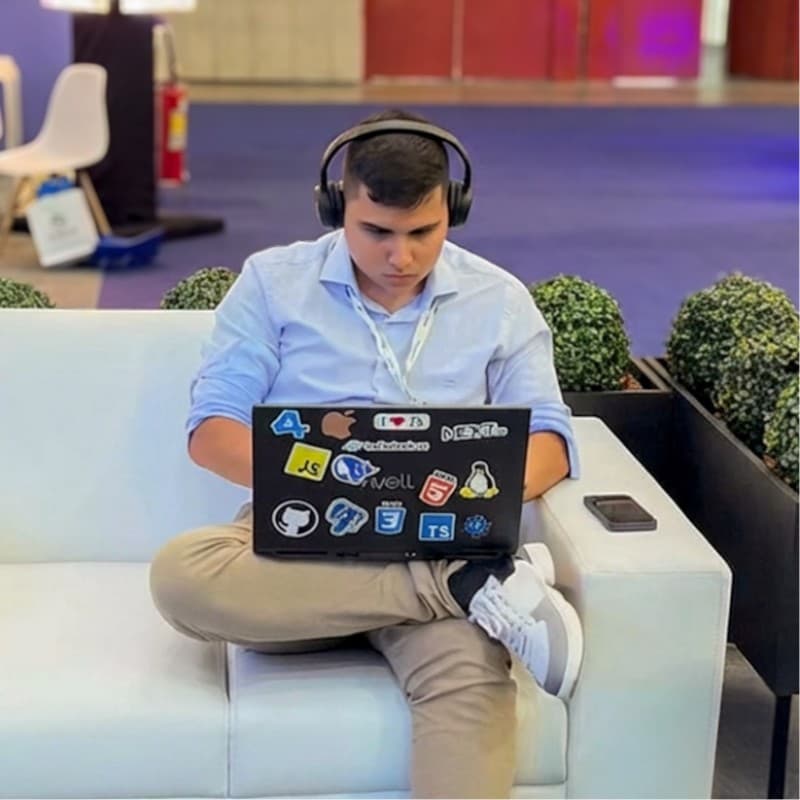 Carlos David trabalhando em um notebook durante um evento de tecnologia